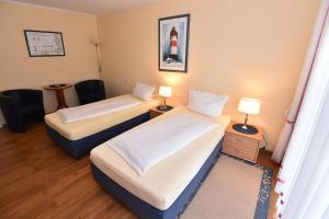 um quarto de hotel com duas camas e duas lâmpadas em Bremer Apartmenthotel Superior em Bremen