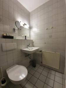 a bathroom with a toilet and a sink at Waldhotel Surwold in Surwold +22 photos