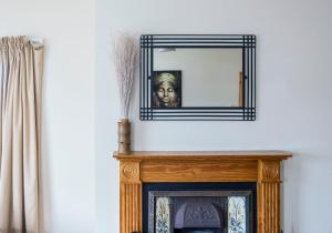 a mirror over a fireplace with a bust of a man at Portbeg Holiday Homes at Donegal Bay in Bundoran