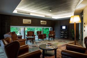 فندق غراند ترينتو في ترينتو: غرفة انتظار مع كراسي وطاولة وتلفزيون
