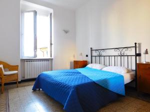 una camera con un letto blu e una finestra di Welcome to alma's house a Levanto