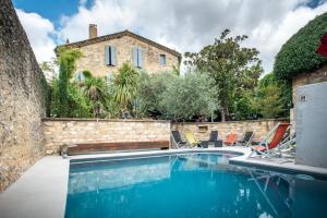 una piscina con sillas y una casa en Le Castellas Hotel & SPA - TERITORIA, en Collias