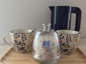 a glass appliance next to two cups on a table at La Clé du Puy in Cabariot