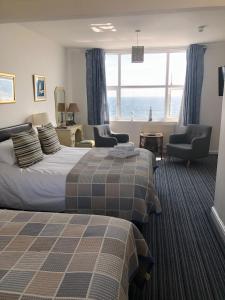 een hotelkamer met 2 bedden en uitzicht op de oceaan bij Mariners Hotel in Seaton