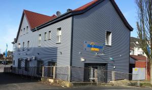 un bâtiment bleu avec un panneau sur son côté dans l'établissement Casino Hotel Neubeckum, à Neubeckum