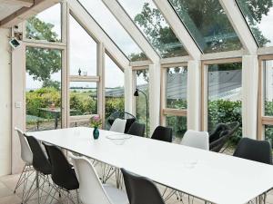Årøsundにある24 person holiday home in Haderslevの白い大きなテーブルと椅子が備わる客室です。