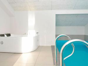 Kelstrupにある12 person holiday home in Haderslevの青い椅子とバスタブが備わる客室です。