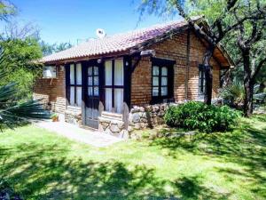 una piccola casa in mattoni in un cortile alberato di Cabanas en el Jardin Nativo a San Francisco del Monte de Oro