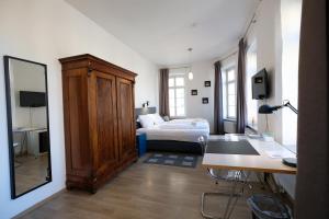 Schlafzimmer mit einem Bett, einem Schreibtisch und einem Spiegel in der Unterkunft Elisabeth Apartments in Marburg an der Lahn