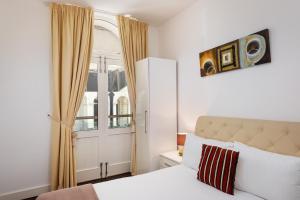 a bedroom with a white bed and a window at Strathmore House Apartments in Plymouth