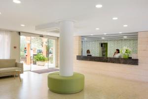 a lobby with a column in the middle of a room at HSM Club Torre Blanca in Sa Coma