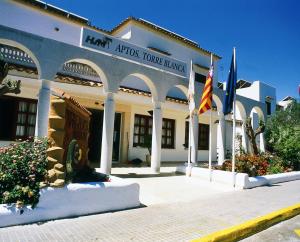um grande edifício com bandeiras à sua frente em HSM Club Torre Blanca em Sa Coma