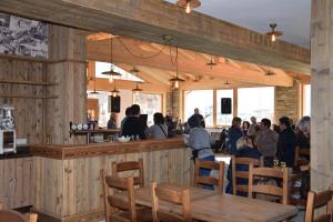 a group of people sitting at a bar in a restaurant at Adda Vegia in Buglio in Monte