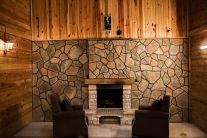 a stone fireplace in a living room with two chairs at Havva Sultan Konağı in Trabzon