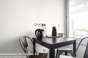 a dining room table with two coffee makers on it at Akicity Sete Rios Selected in Lisbon