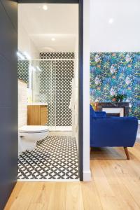 uma casa de banho com um sofá azul e um WC num quarto em Résidence Colonel em Laval