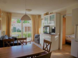 a kitchen and living room with a table and a dining room at Appartementhaus Strandstrasse 16 in Kühlungsborn