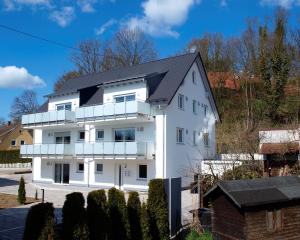 une maison blanche avec un toit noir dans l'établissement Gästehaus Munk, à Guntzbourg