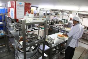 two chefs in a kitchen preparing food in a kitchen at Saiesh International Hotel in Mapusa +19 photos