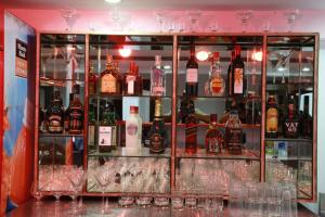 a display case filled with lots of bottles of alcohol at Saiesh International Hotel in Mapusa