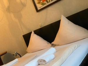 a bedroom with a bed with white sheets and pillows at Hotel Restaurant Memo in Mannheim