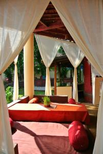 1 dormitorio con 1 cama grande con almohadas rojas en "Sunny Cow" Village Villa, en Anjuna