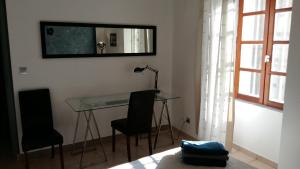 a desk and two chairs in a room with a mirror at Appartement Belle Croix in Avignon