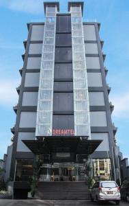 a building with a car parked in front of it at Dreamtel Jakarta in Jakarta