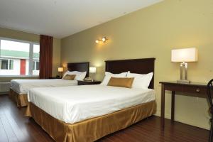 a hotel room with two beds and a window at Hotel Le Voyageur in Quebec City