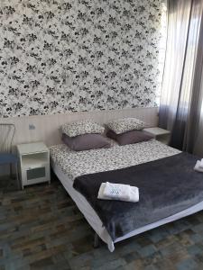 1 dormitorio con 1 cama con papel pintado en blanco y negro en РАЗЪЕЗЖАЯ ул 42, en San Petersburgo