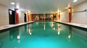 a swimming pool with blue water in a building at Hotel Le Voyageur in Quebec City