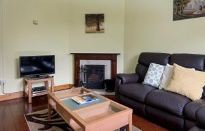 a living room with a couch and a coffee table at Bunhovil - 2 Bedroom Bungalow in Bundoran