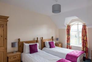 two beds in a bedroom with a window at Atlantic Point Sea View Apartment in Bundoran