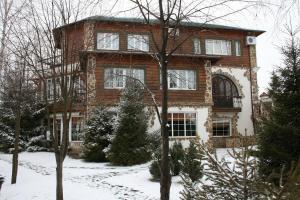 ein großes Backsteinhaus mit Schnee davor in der Unterkunft Hotel Orlinoye Gnezdo in Subottsi