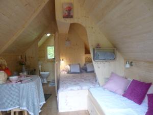a room with a bed and a table in a cabin at Les cabanes de Kerellou in Plouigneau