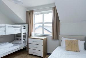 a bedroom with two bunk beds and a window at Marine Court Ground Floor Apartment in Bundoran
