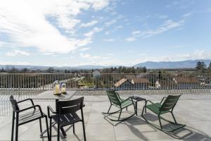 a patio with chairs and a table with a view at Appart'City Collection Genève Aéroport - Vernier in Geneva