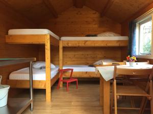 a bunk bed room with two bunk beds and a table at Camping Engelbert (Groningen) in Groningen