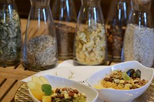 a table with bowls of food and glass jars of nuts at Genusshotel Hirschen - Erholung im Grünen (Südschwarzwald) in Sallneck