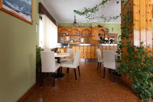 聖卡特琳娜瓦爾夫的住宿－莫布勒阿德勒酒店- 客房和山區公寓，一间带桌子和白色椅子的用餐室