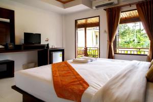 a bedroom with a large white bed with a window at Baan Rabieng Resort in Ko Lanta