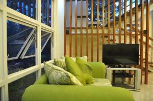 eine grüne Couch vor einem Fernseher in der Unterkunft Greenspace Palawan in Puerto Princesa