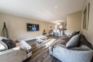 sala de estar con 2 sofás y comedor en Courtyard Holiday Homes en Southport