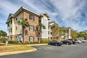 a large house with cars parked in a parking lot at Magnolia Pointe Myrtle Beach Condo on Golf Course! in Myrtle Beach