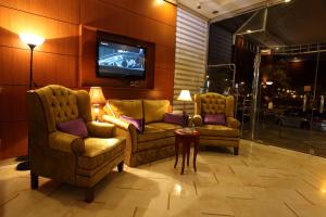 sala de estar con 2 sillas y TV en Lavande Suites en Yanbu