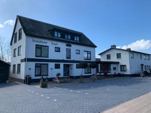 a large white building on a brick street at DuinHotel Texel in De Koog