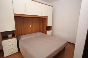 Dormitorio pequeño con cama y armarios blancos en Villa Tatiana appartamento en Rosolina Mare