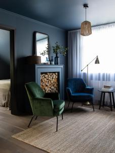 una sala de estar con una silla verde y un espejo en INNI - Boutique apartments en Hveragerði