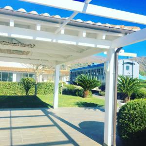 a white pergola in front of a building at Skipper White Guest House in Trevignano Romano