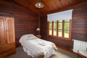 um quarto com uma cama e uma janela em Hostería El Galpón Del Glaciar em El Calafate